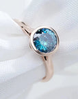 One Carat Portuguese Round Cut Vivid Blue Moissanite Bezel Set Engagement Ring in 18 Karat Rose Gold - Boutique Pave