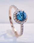 One Carat Round Portuguese Cut Blue Moissanite Halo Engagement Ring in 18 Karat Rose Gold - Boutique Pave