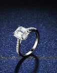 Two Carat Emerald Cut Moissanite Halo Engagement Ring in Platinum Plated Sterling Silver - Boutique Pavè