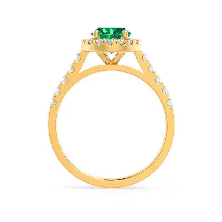 Two Carat Oval Cut Lab Created Emerald and Pave Moissanite Halo Engagement Ring in 18 Karat Yellow Gold - Boutique Pavè